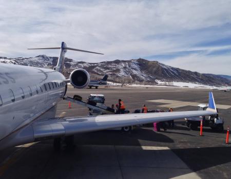 Plane on a tarmac with mountains in the background 