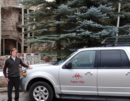 Aspen Alps car with a staff member standing outside 