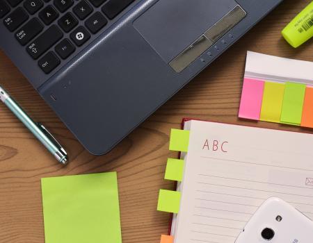Stock image of a laptop and notes 