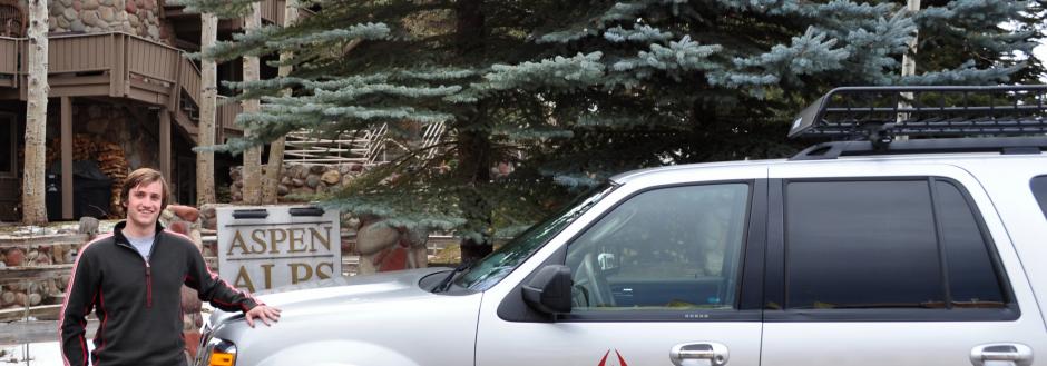 Man standing with his car infront of Aspen Alps resort 