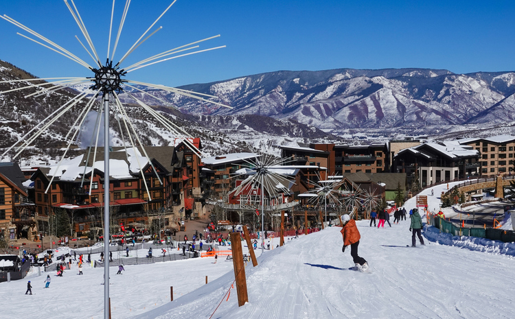 Skiers, snowboarders, and lifts at the base of Snowmass ski resort, Aspen, Colorado.